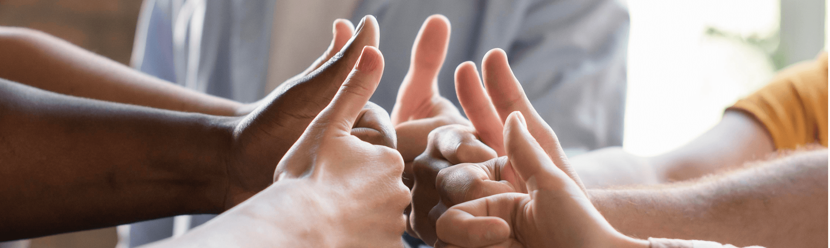 Hands giving thumbs up in a group